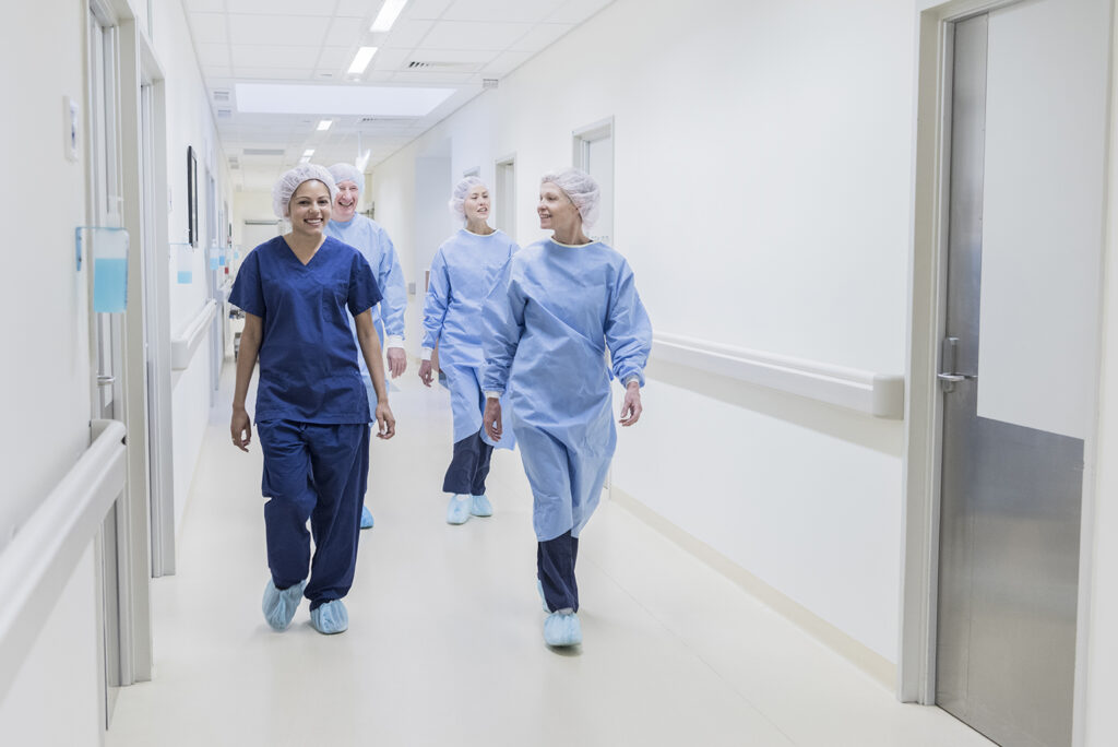 women walking in scrubs through hospital